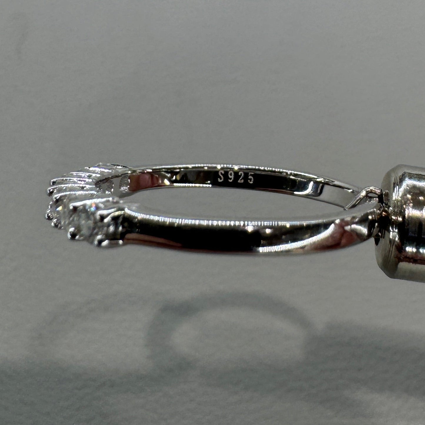 Close-up of a silver fishing hook against a neutral background