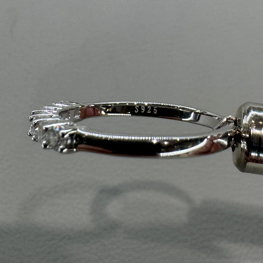 Close-up of a silver fishing hook against a neutral background