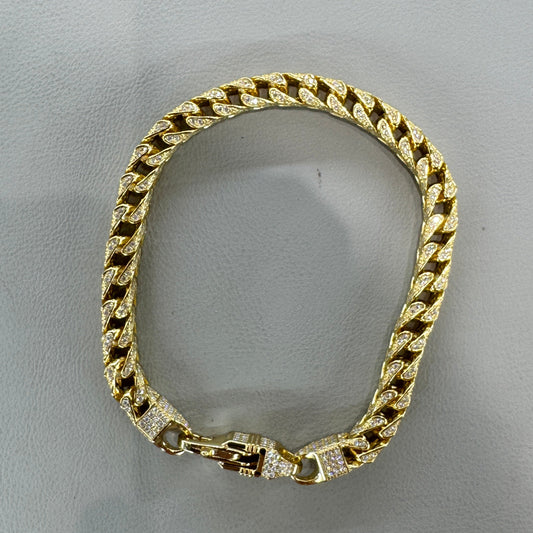 Gold chain bracelet on a gray background