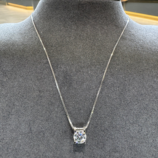Silver necklace with a diamond pendant on a mannequin bust.