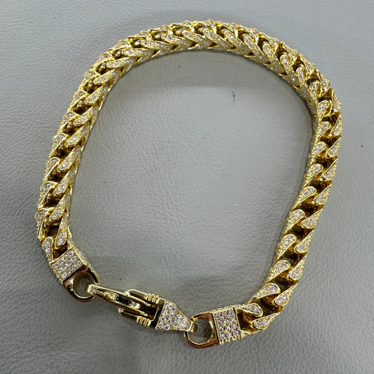 Gold chain bracelet on a gray background