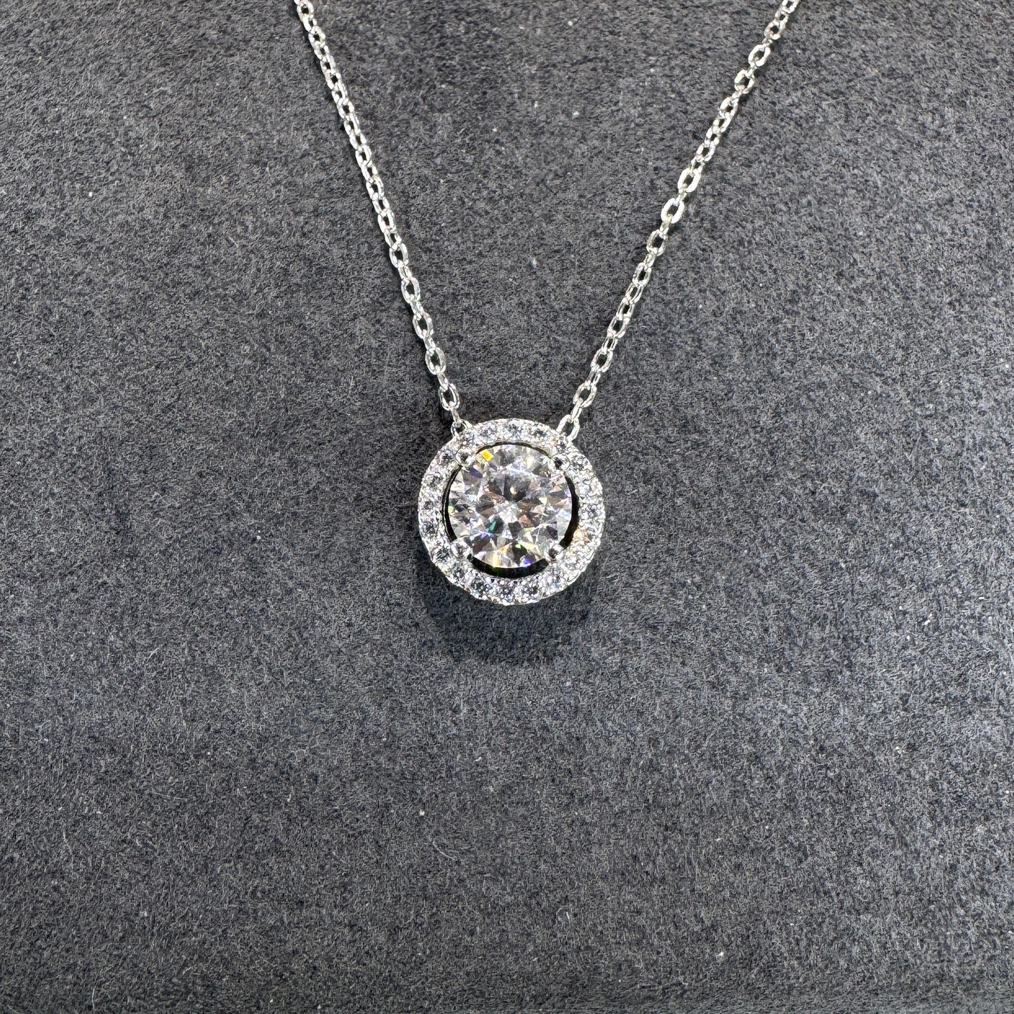 Sterling silver circular pendant detail showing 1ct moissanite stone brilliant fire Model MJE1098
